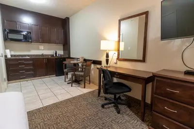 a hotel room with a desk and a mirror at BCMInns - Lac La Biche in Lac La Biche