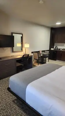 a hotel room with a large bed and a desk at BCMInns - Lac La Biche in Lac La Biche
