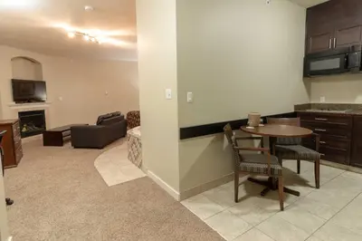 a kitchen and living room with a table and a couch at BCMInns - Lac La Biche in Lac La Biche