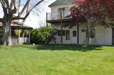 a house with a tree in the yard at Summerland Motel in Summerland