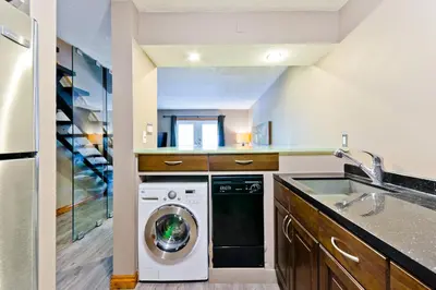 a kitchen with a washing machine and a sink at M Lofts in Calgary