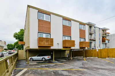 a building with a car parked in a parking lot at M Lofts in Calgary