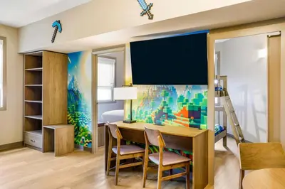 a room with a desk and a bedroom with a bed at Days Inn & Suites by Wyndham West Edmonton in Edmonton