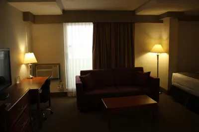 a hotel room with a couch and a bed and a television at Ramada by Wyndham Edmonton South in Edmonton