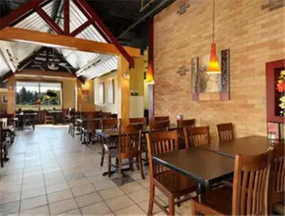 a dining room with tables and chairs in a restaurant at Ramada by Wyndham Edmonton South in Edmonton