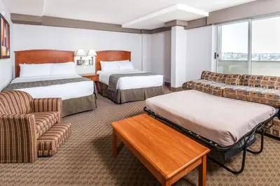 a hotel room with two beds and a couch at Ramada by Wyndham Edmonton South in Edmonton