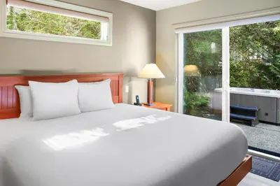a bedroom with a bed and a large window at Long Beach Lodge Resort in Tofino