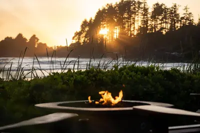 a fire pit with the sunset in the background at Long Beach Lodge Resort in Tofino