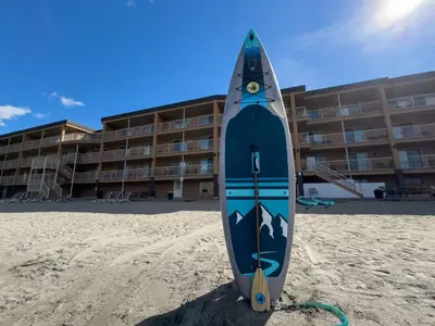 a blue kayak on the beach in front of a hotel at Coast Osoyoos Beach Hotel in Osoyoos