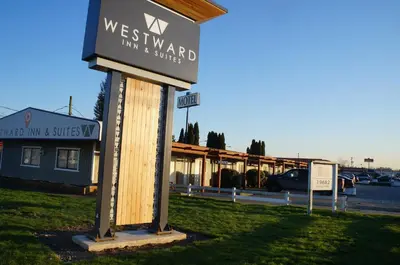 a sign for a westward inn and suites in front of a building at Westward Inn & Suites in Langley
