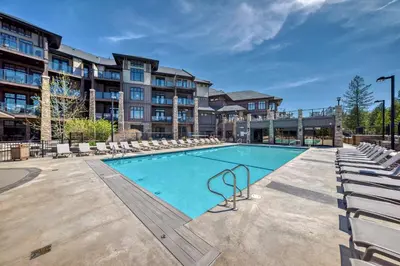 a swimming pool at a apartment complex with chairs at Copper Point Resort in Invermere