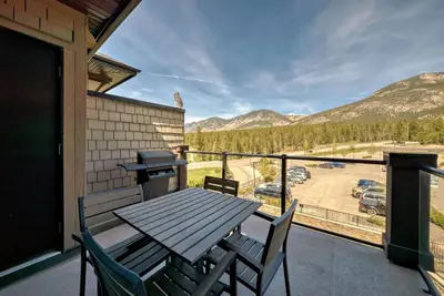 a table and chairs on a balcony with a view at Copper Point Resort in Invermere