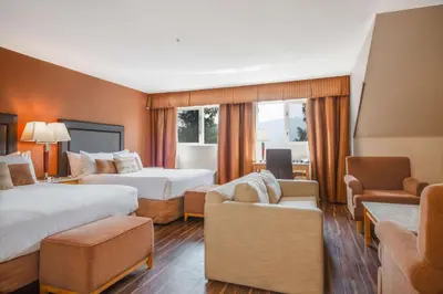 a hotel room with two beds and a couch at Coast Hillcrest Hotel in Revelstoke