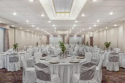 a banquet hall with white tables and chairs at Ramada by Wyndham St Paul AB in St. Paul