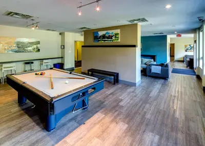 a room with a pool table and a living room at HI Whistler - Hostel in Whistler