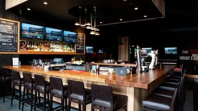 a bar with leather chairs and a counter in a restaurant at Coast Hotel & Convention Centre in Langley