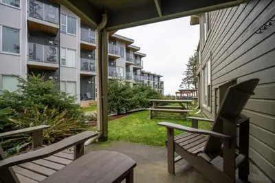 two benches sitting on the porch of a apartment building at Pacific Sands Beach Resort in Tofino