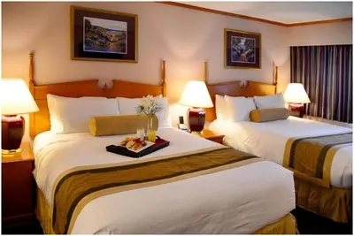 a hotel room with two beds and two lamps at The Hospitality Inn in Port Alberni