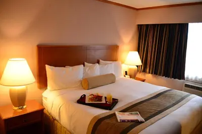 a hotel room with a bed with a tray of food on it at The Hospitality Inn in Port Alberni