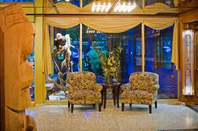 two chairs and a table in front of a window at Crest Hotel in Prince Rupert