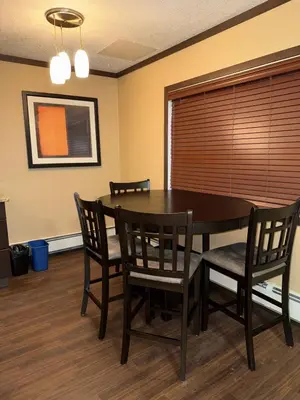 a dining room with a black table and chairs at Siding 16 Lodge in Wetaskiwin