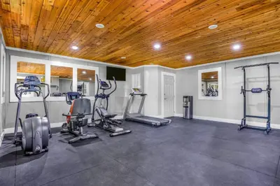 a gym with treadmills and ellipticals and a wooden ceiling at Days Inn by Wyndham Golden in Golden