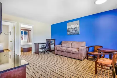 a living room with a couch and a blue wall at Days Inn by Wyndham Golden in Golden