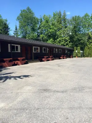 a building with picnic tables in a parking lot at Copper River Motel in Terrace