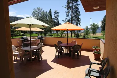an outdoor patio with tables and chairs and umbrellas at Waterfront Inn in Penticton