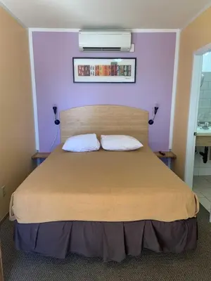 a bedroom with a large bed with purple walls at Waterfront Inn in Penticton
