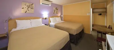 a hotel room with two beds and a table at Waterfront Inn in Penticton