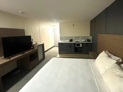 a hotel room with a bed and a flat screen tv at SureStay by Best Western Smithers in Smithers