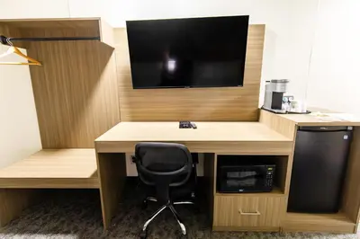 a desk with a tv and a chair in a room at SureStay by Best Western Smithers in Smithers