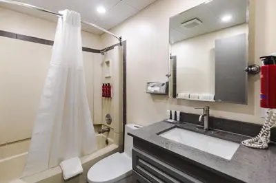 a bathroom with a shower and a sink and a toilet at SureStay by Best Western Smithers in Smithers
