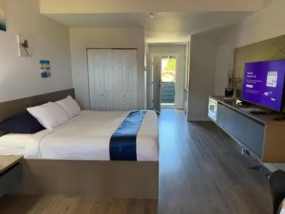 a bedroom with a bed and a flat screen tv at Sand Pebbles Inn in Qualicum Beach