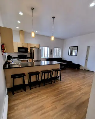 a kitchen with a counter and stools in a room at Fireweed Motel in Smithers