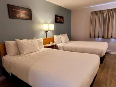 a hotel room with two beds and a window at Fireweed Motel in Smithers