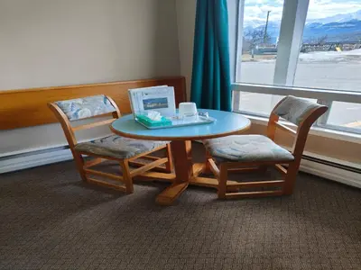 a table and two chairs and a table and a window at Ponderosa Motor Inn in Golden