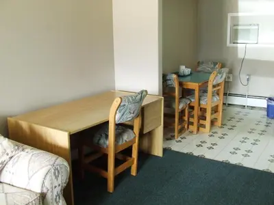 a room with a desk and two chairs and a table at Ponderosa Motor Inn in Golden