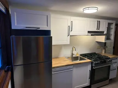 a kitchen with white cabinets and a stainless steel refrigerator at Winston Lodge in Golden