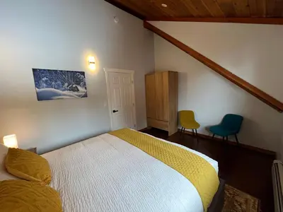 a bedroom with a bed and two chairs in it at Winston Lodge in Golden