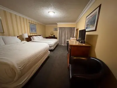 a hotel room with two beds and a television at Island Travel Inn in Victoria