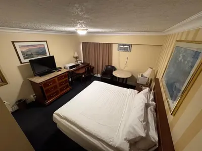 a hotel room with a bed and a desk at Island Travel Inn in Victoria