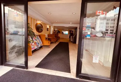 a store front with glass doors and a black rug at Island Travel Inn in Victoria