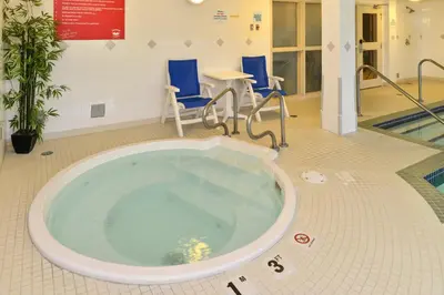 a large tub in a room with chairs and a table at Holiday Inn Express Edmonton North by IHG in Edmonton