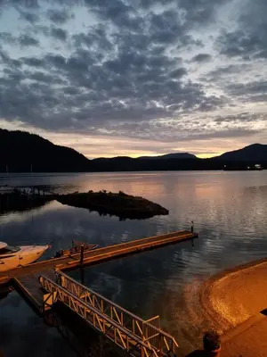a dock on a body of water at sunset at Oceanfront Suites at Cowichan Bay in Cowichan Bay