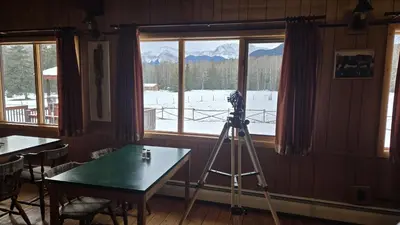 a camera on a tripod in a room with a table at Black Cat Guest Ranch in Brule Mines