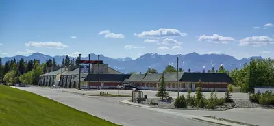 a building on a street with mountains in the background at Crestwood Hotel in Hinton