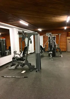 a gym with several treadms and machines in a room at Crestwood Hotel in Hinton