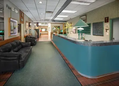 a hospital lobby with a large blue bar at Crestwood Hotel in Hinton